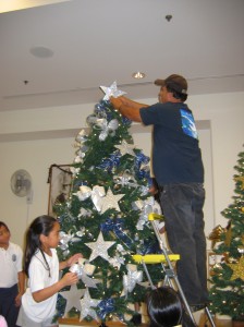 Uncle David tops off our blue and silver tree.