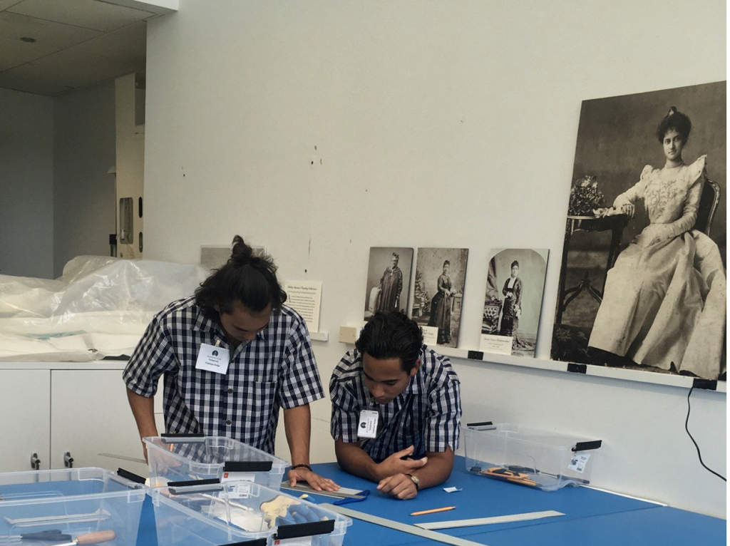 Makana & Keoni help design exhibit cases for kāhili with Bishop Museumʻs curators